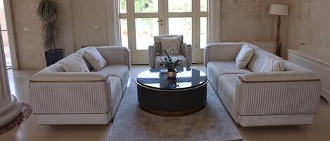 A living room with two sofas, a coffee table, and a door with a view.