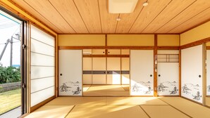 A traditional Japanese room with tatami flooring, sliding doors, and shoji screens. - Green Beach le Island (Ie)