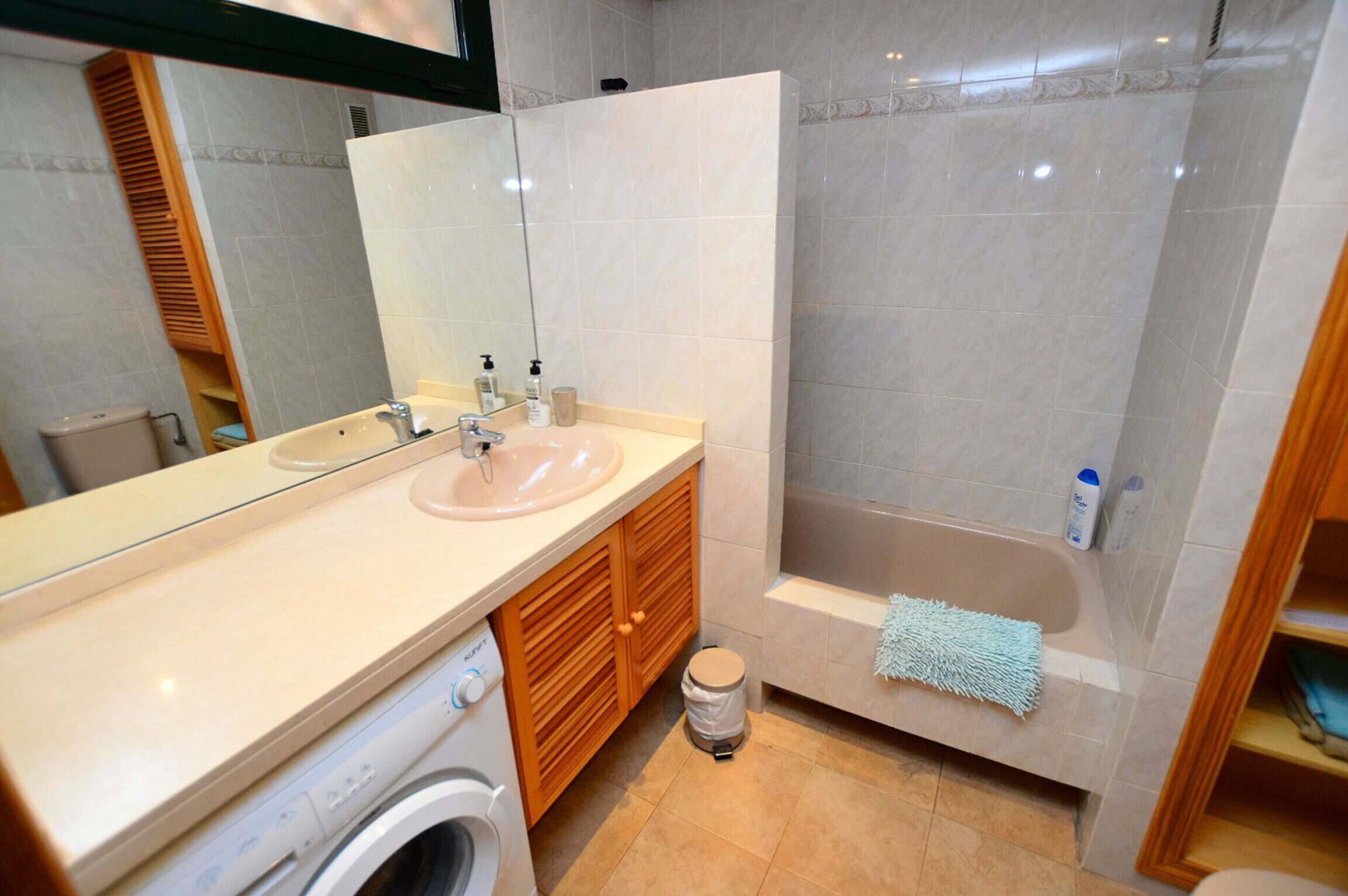 A bathroom with a sink, mirror, toilet, and shower.