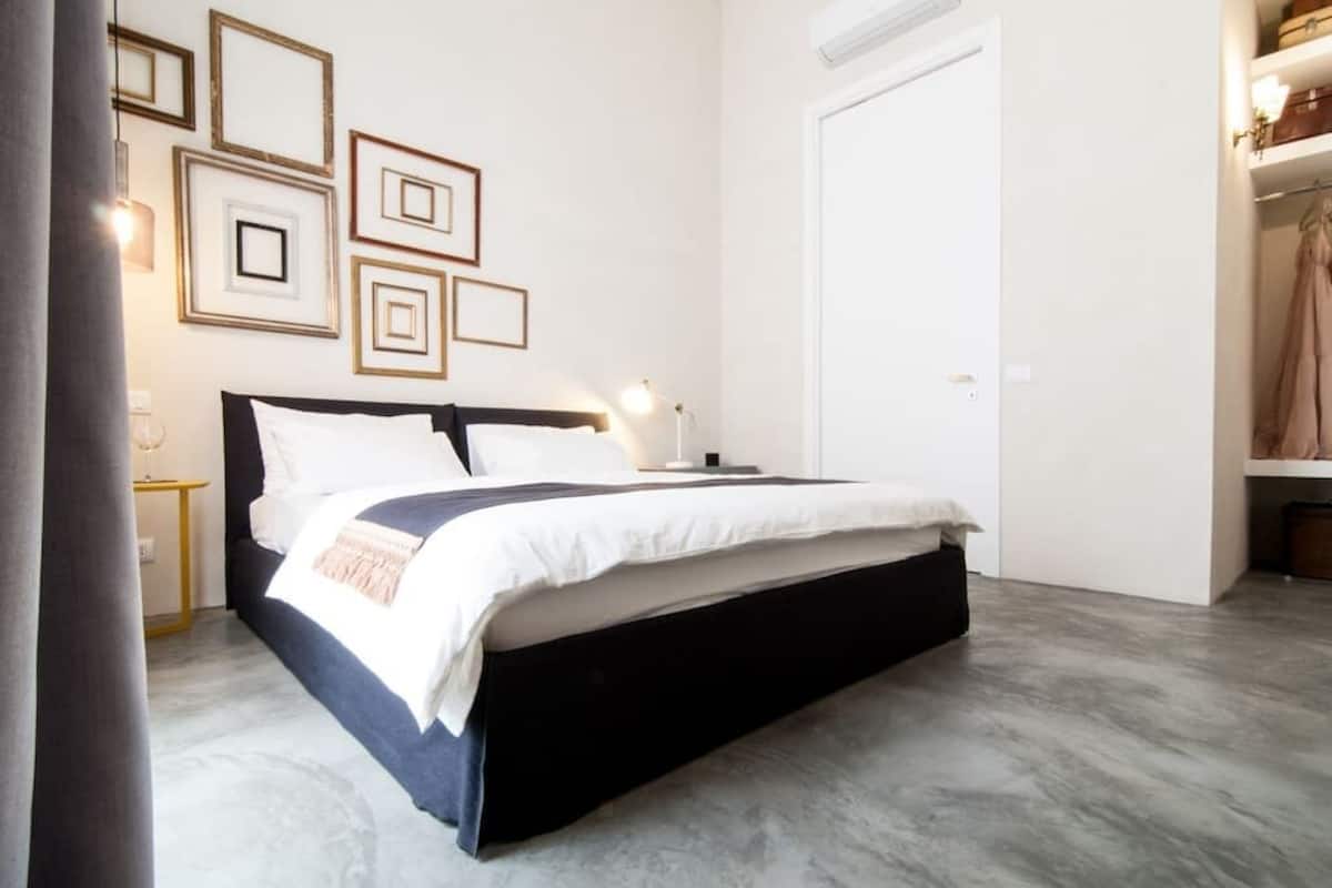 Une chambre à coucher moderne avec un grand lit, des tables de chevet et une armoire.
