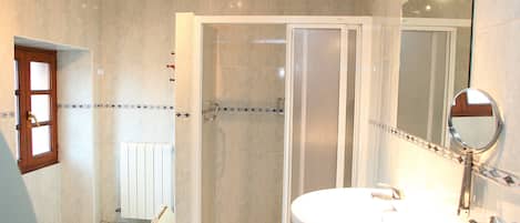 Un baño con ducha, inodoro y lavabo.