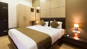 A hotel room with a bed, bedside lamps, a wardrobe, and a nightstand. - Dean Villa (Mawal)