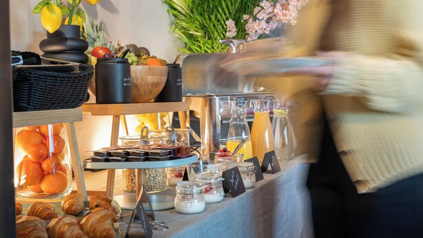 Un buffet con diversi cibi e una persona sullo sfondo.