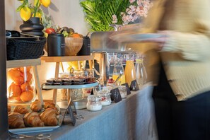 A buffet with various food items and a person in the background. - House of Records (Munich)