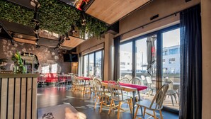 Un ristorante moderno con posti a sedere interni, ampie finestre e una zona esterna ben visibile.