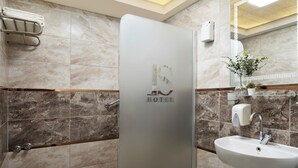 A modern bathroom with a toilet, sink, and shower. - IS Hotel (Antalya)