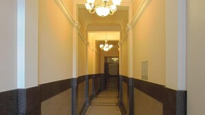 A long, narrow hallway with a carpeted floor and a series of light fixtures along the ceiling. - Booking Rooms (Belgrade)