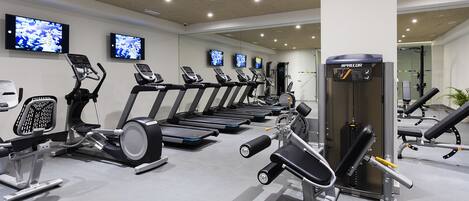 A gym with treadmills, elliptical machines, and weightlifting equipment.