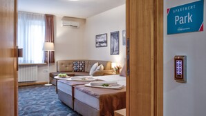 Una habitación de hotel con cama, sofá, escritorio y aire acondicionado de pared.