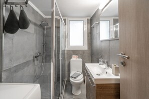 A modern bathroom with a shower, toilet, and sink. - Urban Serenity Gem in Kallithea Area (Kallithea)
