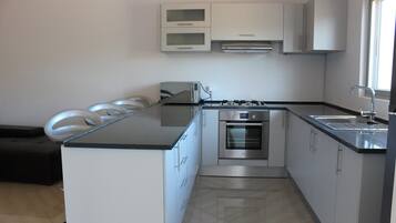 Appartamento Comfort | Cucina privata | Frigorifero con congelatore, microonde, forno, piano cottura