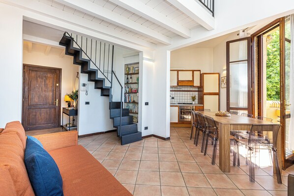 Un intérieur moderne comprenant un escalier, un coin repas et une cuisine.