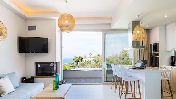 Ein modernes Wohnzimmer mit Sofa, Fernseher und einem Balkon mit Blick.