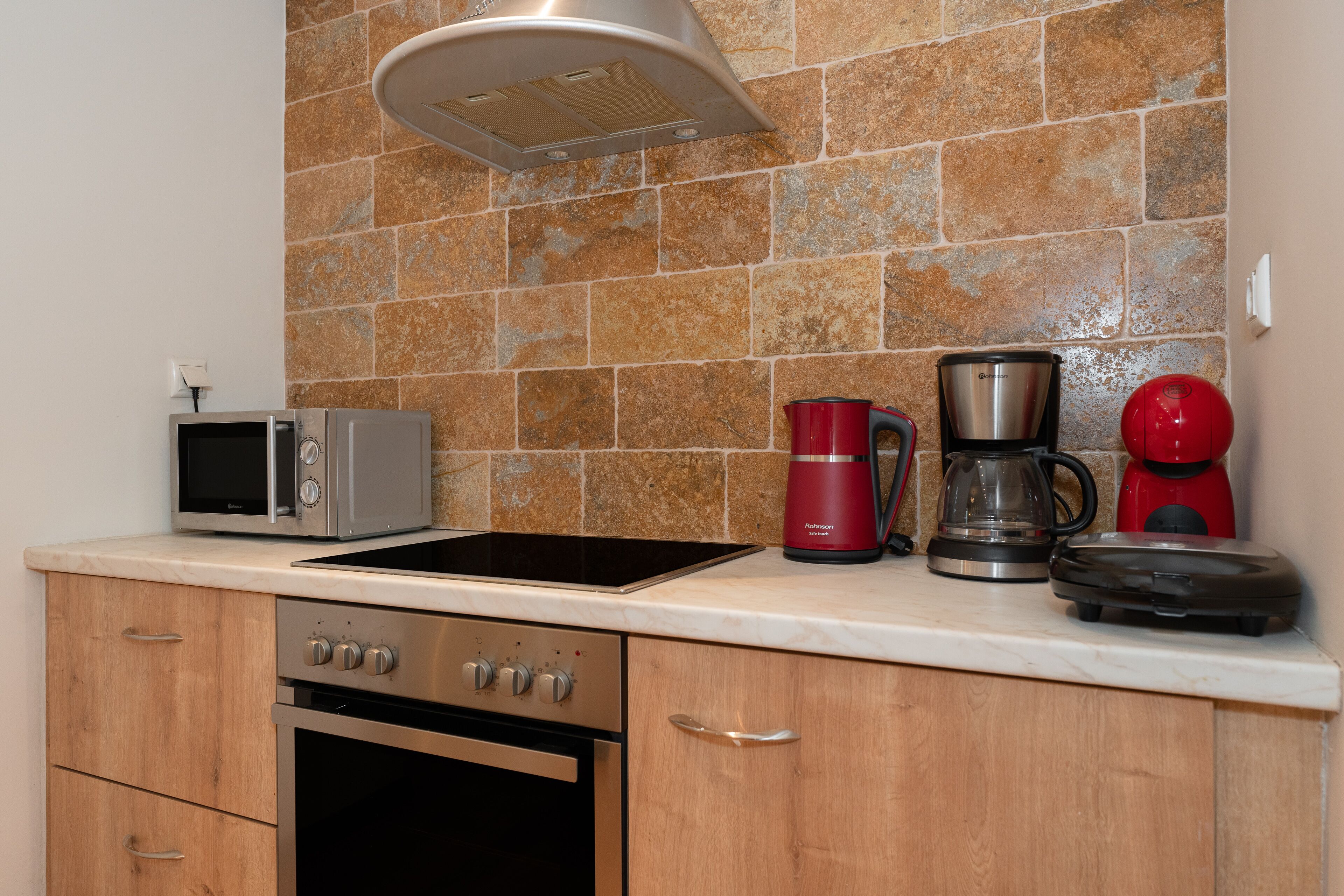 A kitchen with a microwave, coffee maker, and toaster on the counter.