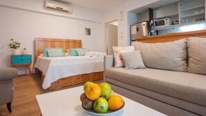 Ein Schlafzimmer mit einem Bett, einem Nachttisch und einer Obstschale auf einem Tisch.
