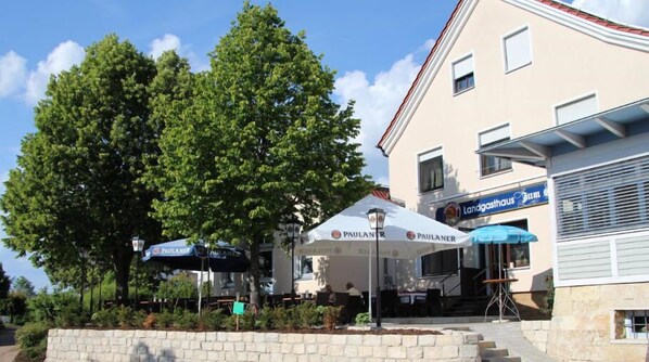 A building with outdoor seating and a sign for 'Landgasthaus'. - Stempfle's Landgasthof Zum Kreuz (Unterschneidheim)