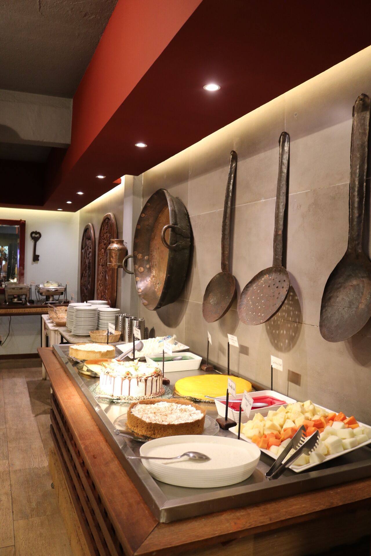 Uma área de buffet com diversos alimentos e utensílios.