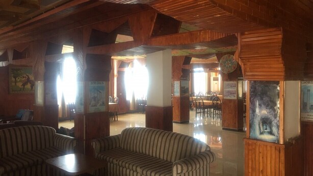A spacious lobby with striped sofas, wooden pillars, and a bright, open layout. - Ajloun Hotel (Ajloun)