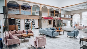 A spacious lobby with a high ceiling, a mezzanine level, and a variety of seating areas including sofas and armchairs.