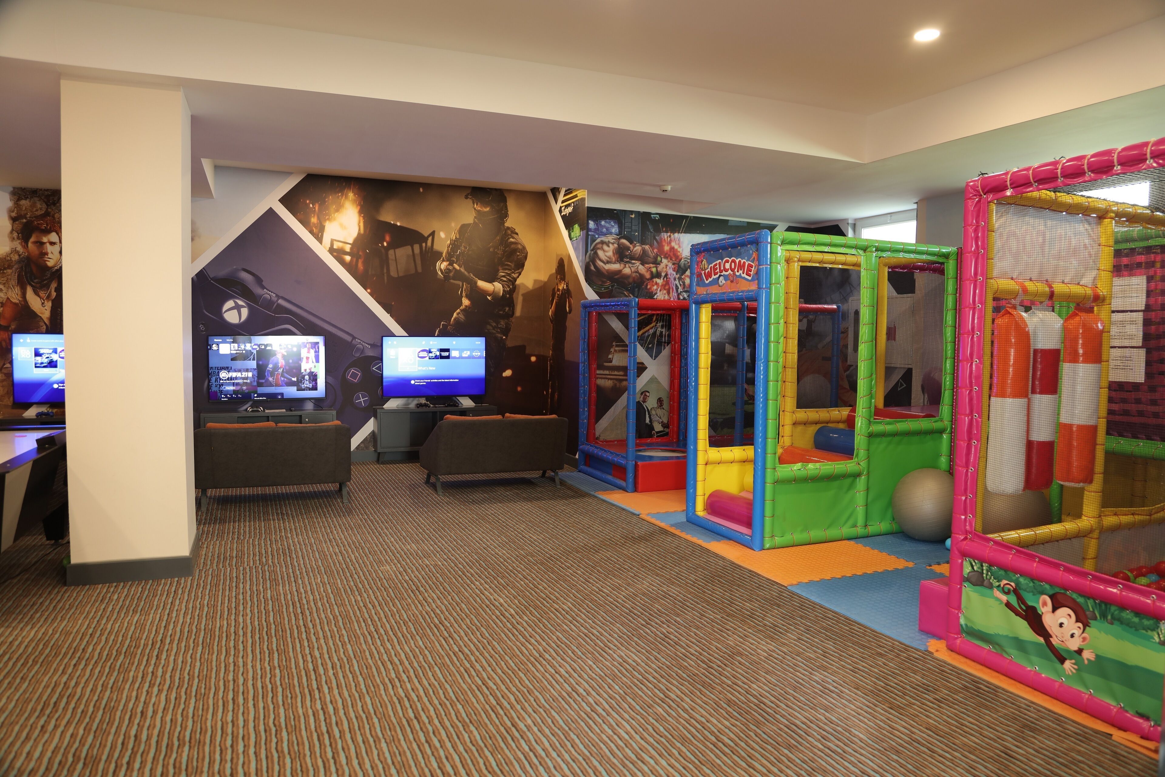 A children's play area with colorful play structures and gaming stations.