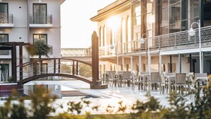 A hotel courtyard with outdoor seating, a bridge, and a pool.
