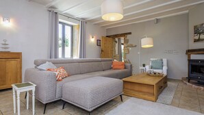 Ein gemütliches Wohnzimmer mit grauem Sofa, einem kleinen Holztisch und einem Kamin.