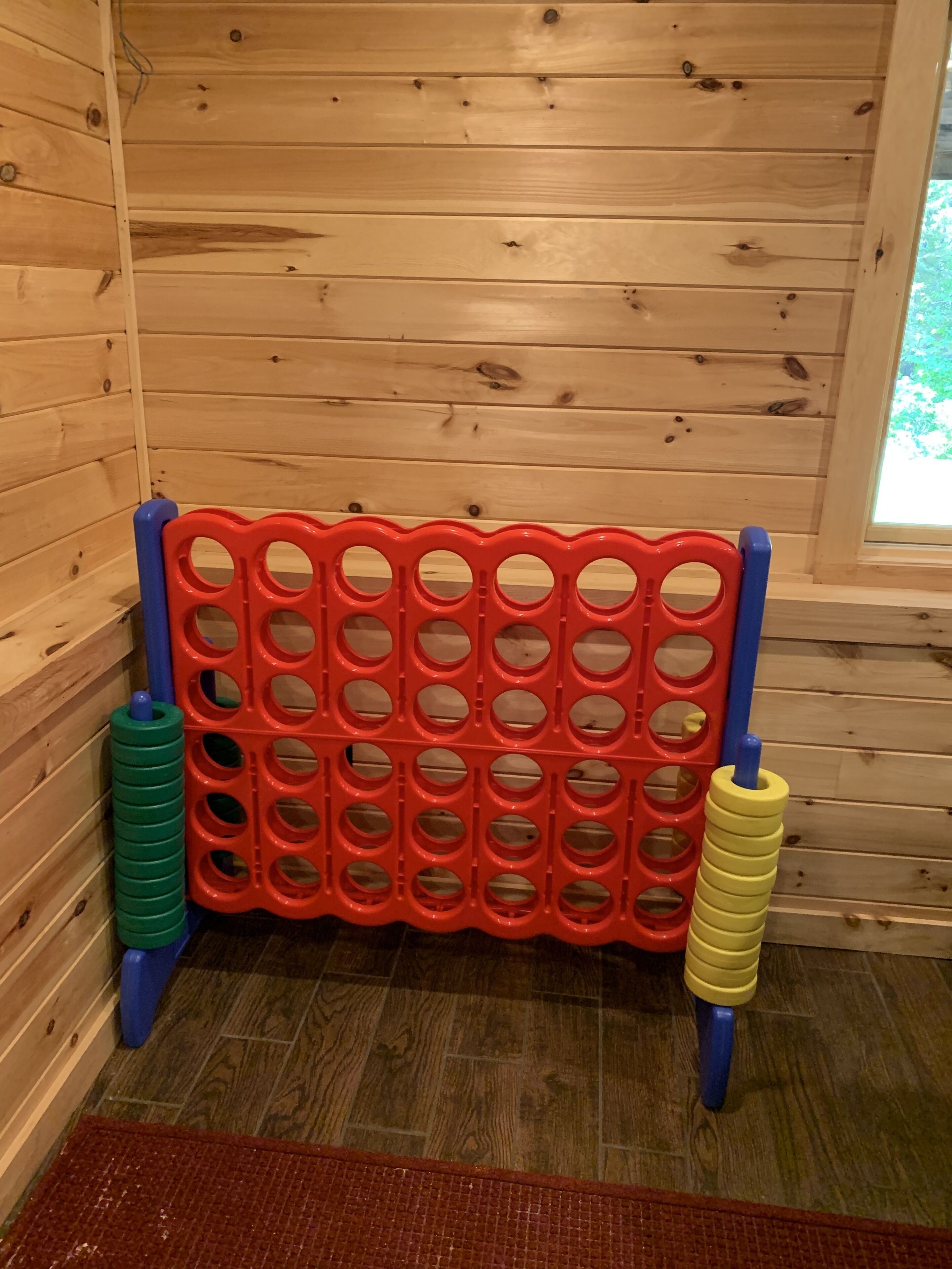 Ein Holzhütten-Innenraum mit einer roten und blauen Spielgelegenheit.
