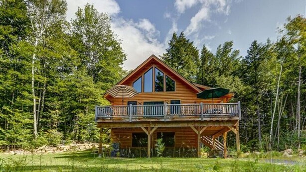 A wooden cabin with a balcony, surrounded by trees. - Gorgeous 4BR Log Home Near Storyland & N. Conway. AC, Large Deck, Dog friendly (Bartlett)