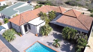 A residential property with a swimming pool, tiled roofs, and palm trees. - Esmeralda Escape - Your Private Oasis (Noord)