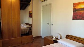 Ein Schlafzimmer mit einem Bett, einem Kleiderschrank, einem Nachttisch und einer Tür.