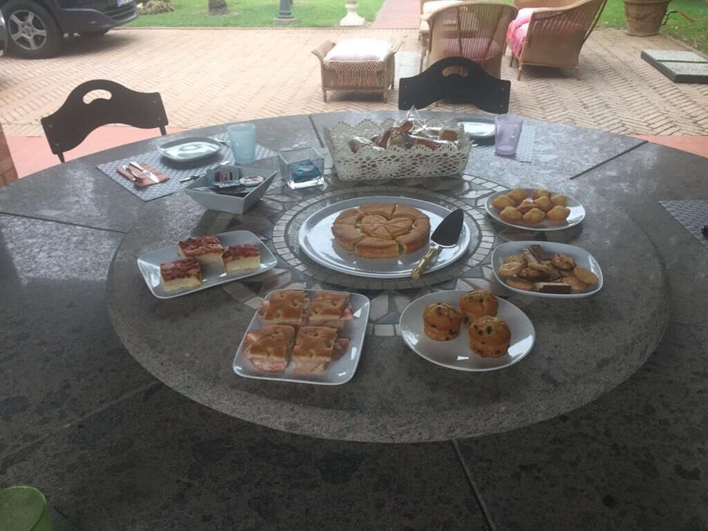 Une table ronde avec divers pâtisseries et un panier de pain.