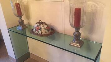 Une étagère en verre avec deux porte-bougies et un objet décoratif.