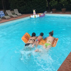 Una piscina al aire libre de temporada, sillones reclinables de piscina