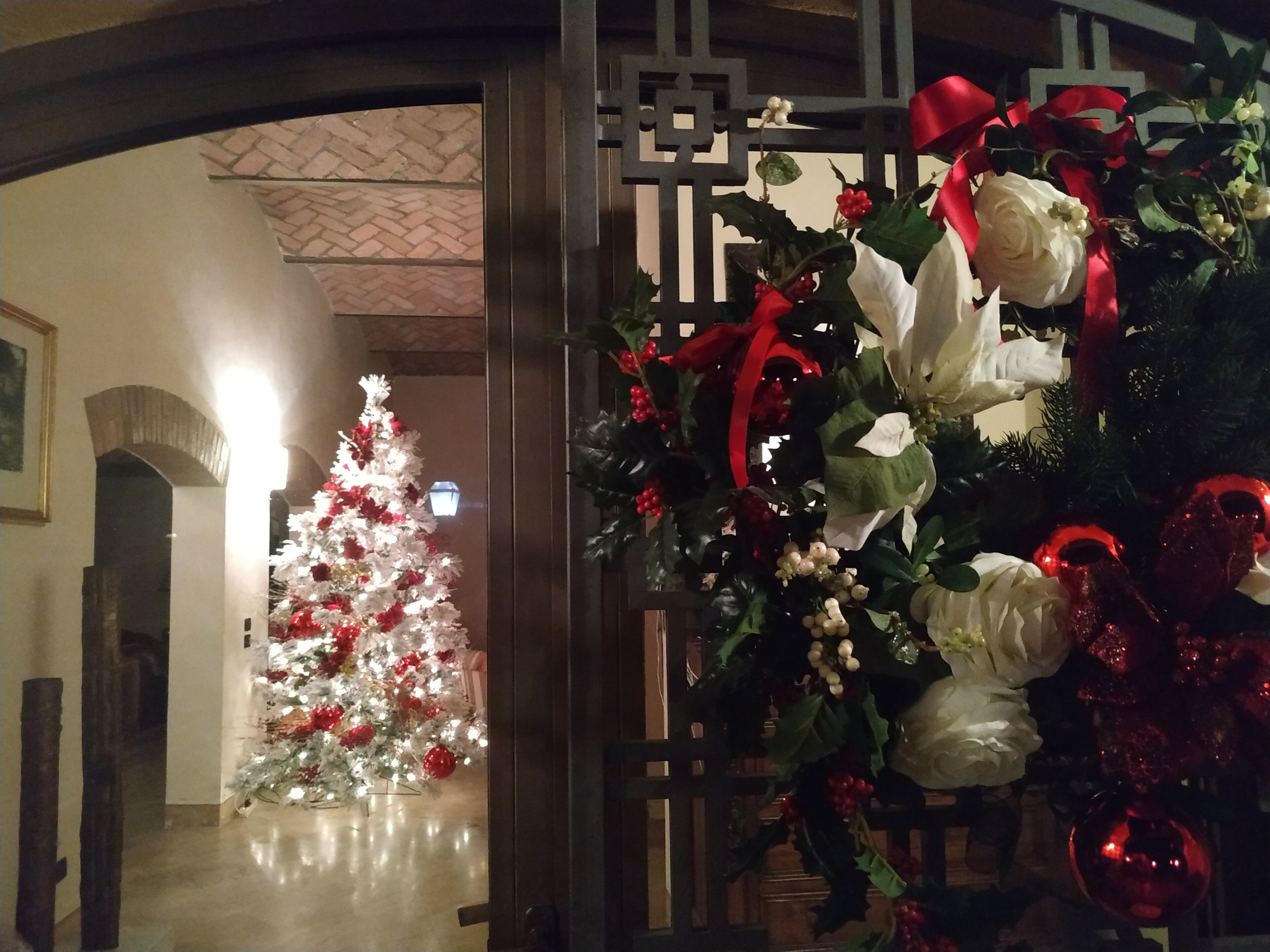 Un sapin de Noël décoré dans un couloir, agrémenté d’une guirlande et de décorations.
