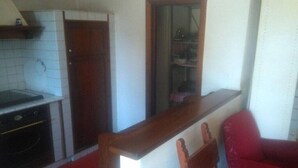 A kitchen with a stove, oven, and a wooden cabinet. - Holiday home in Val di Chiana (Castiglion Fiorentino)