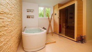 Une salle de bain moderne avec une baignoire sur pieds, un lambris en bois et une grande fenêtre.