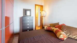 Un dormitorio con una cama, un tocador y una lámpara.