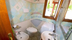 Ein kleines Badezimmer mit Toilette, Bidet und Waschbecken.