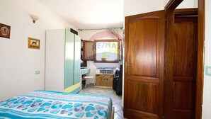 Ein Schlafzimmer mit einem Bett, einer Holztür, einem Schreibtisch und einem Fenster mit Blick.