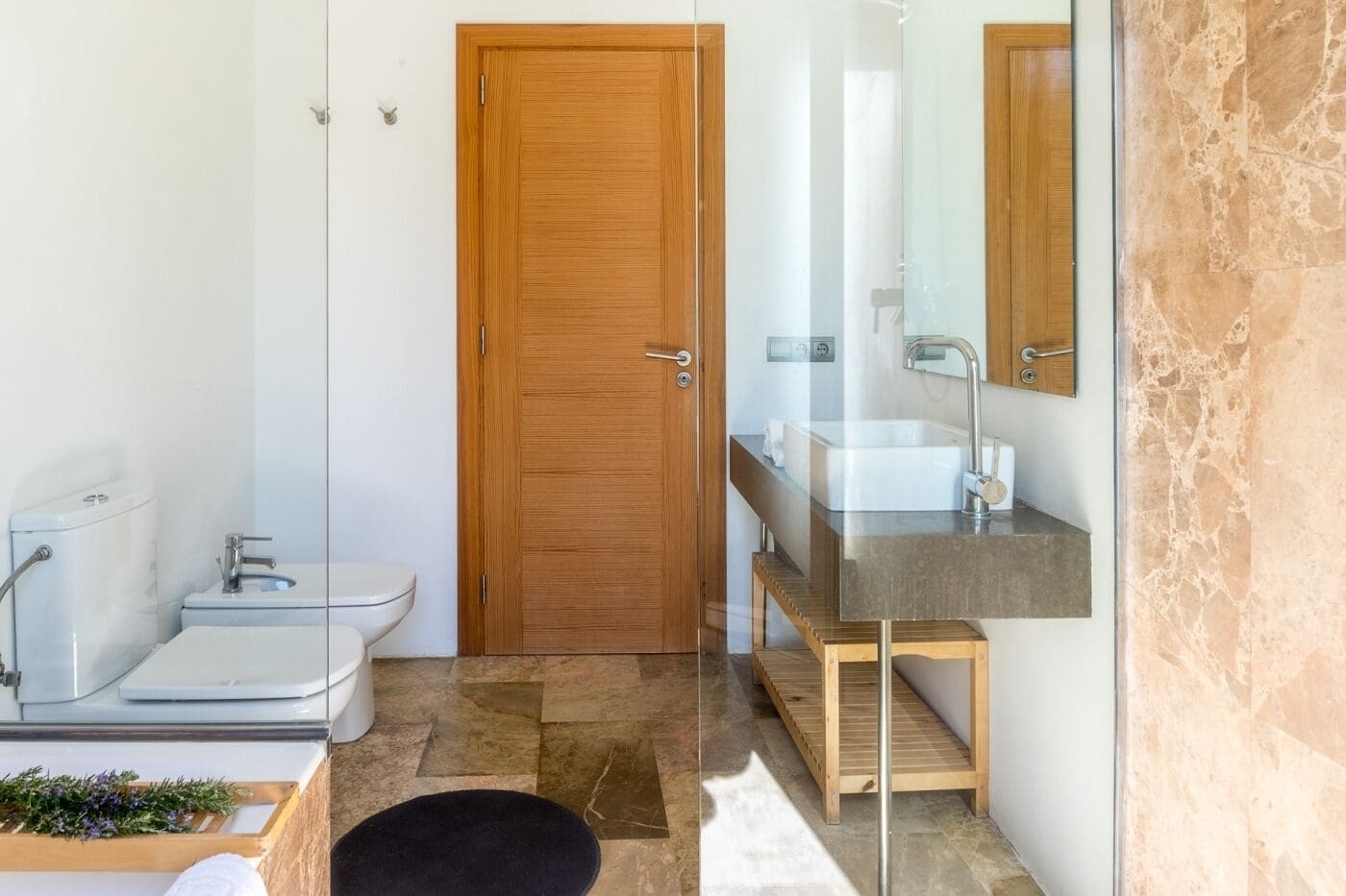 A modern bathroom with a toilet, sink, and mirror.