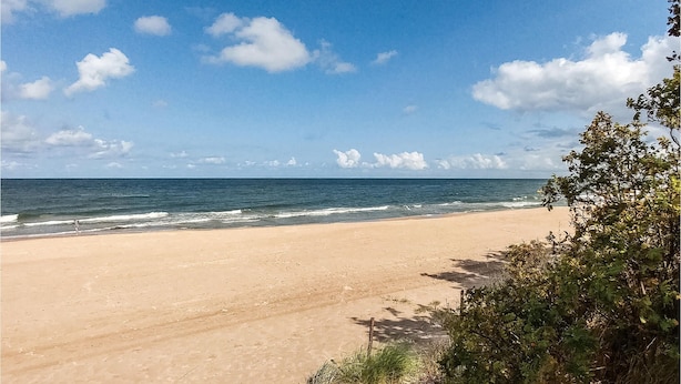 A beach with a clear sky and ocean waves.
