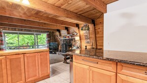 Una cocina con armarios de madera, encimera de granito y un amplio ventanal con vistas a zonas verdes.