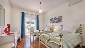 Ein Schlafzimmer mit Bett, Schreibtisch und Stuhl. Ein Fenster mit Vorhängen und Blick nach draußen.