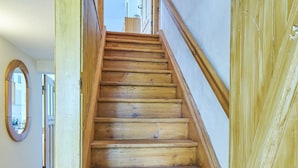 A wooden staircase with a handrail, leading to an upper floor. - Charming farmhouse (Rheinsberg, OT Linow)