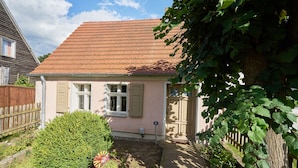 A house with a red-tiled roof, a small front yard, and a wooden fence. - Charming farmhouse (Rheinsberg, OT Linow)