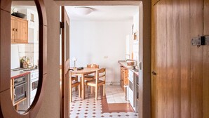 A hallway with wooden flooring, a round mirror, and a wooden door. - Charming farmhouse (Rheinsberg, OT Linow)