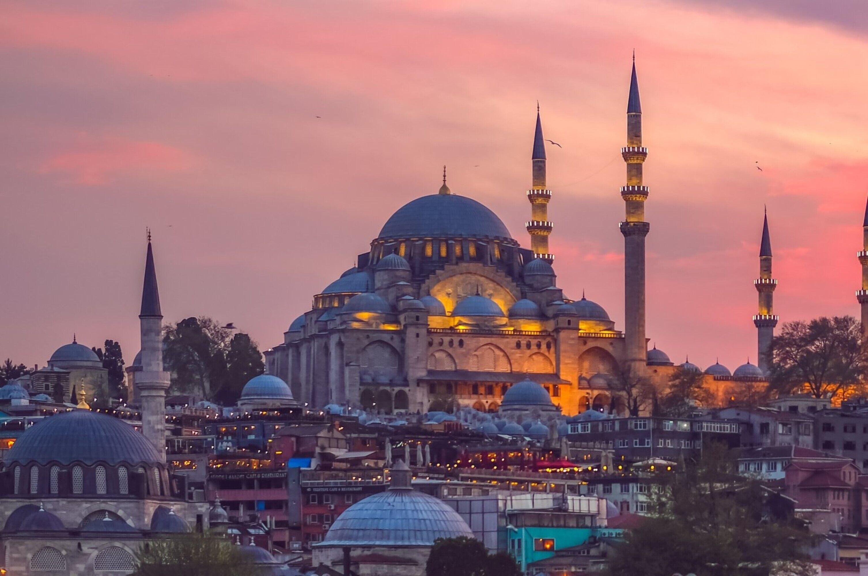 A historic building with multiple domes and minarets, surrounded by other structures.