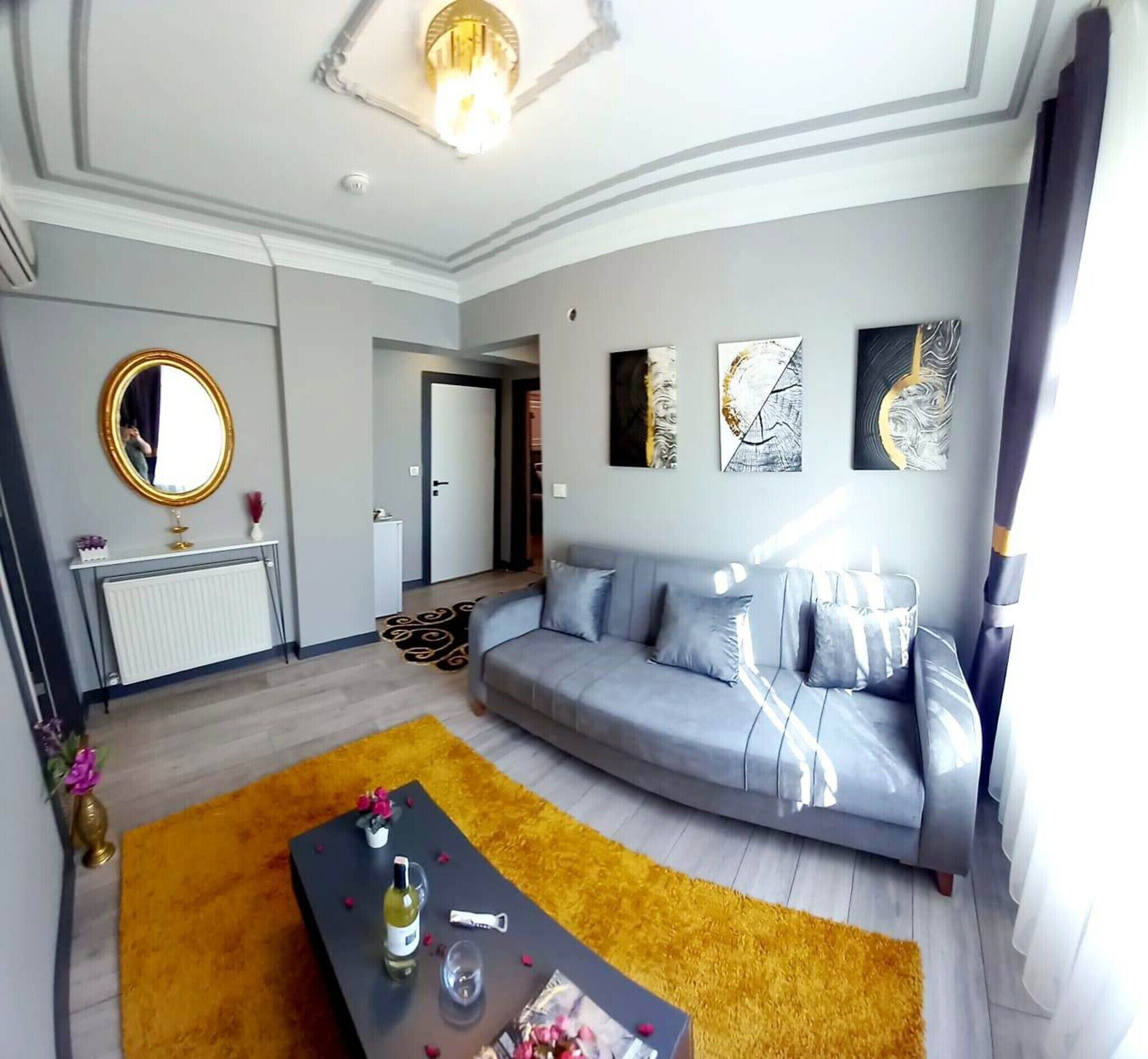 Un salon moderne avec un canapé, une table basse et des œuvres d’art accrochées aux murs.