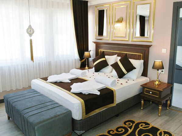 A neatly made bed with white linens, a bedside table with a lamp, and a mirror above the bed.