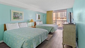 A hotel room with two beds, a dresser, a lamp, and a view of a building through a window. - Ocean view condo, fully renovated + Free Attraction Tickets! (Myrtle Beach)